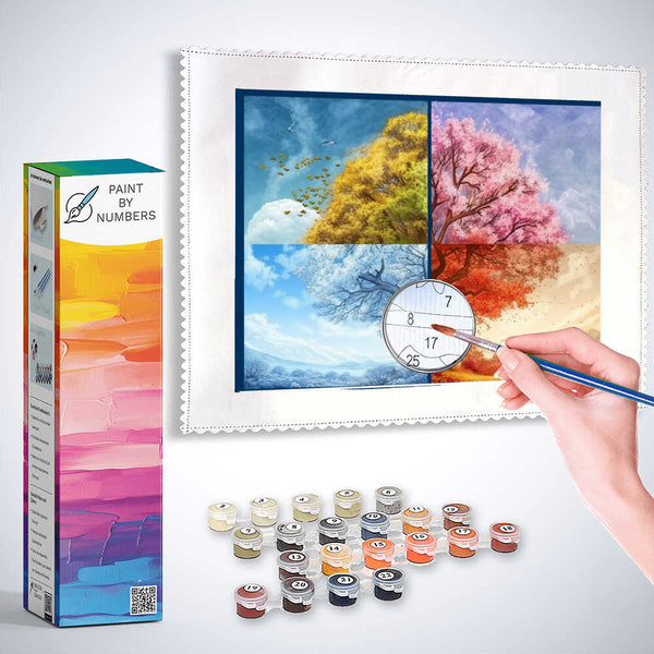 Person painting "Seasons of Longing" Paint by Numbers kit, depicting four seasons with vibrant colors. Paint set and box included in the image.