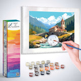 Paint by Numbers kit featuring Alpine Peace Mountain Church with a hand painting rustic stone house and bridge in idyllic landscape