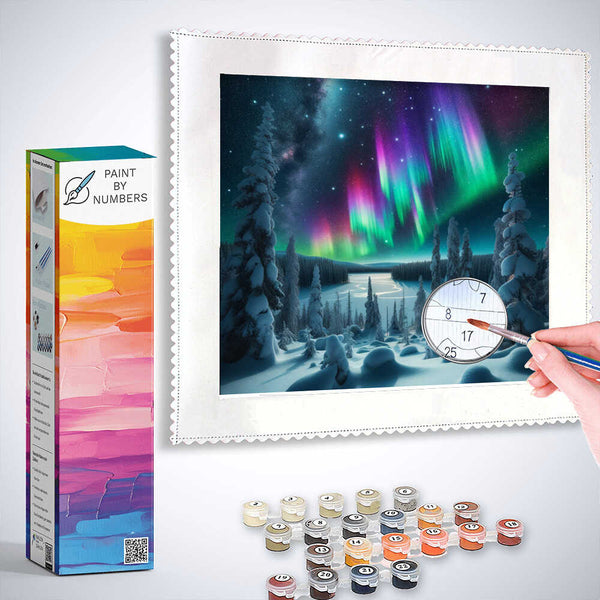 Person painting a Paint by Numbers set depicting Northern Lights over a winter forest with supplied paints.