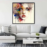 Modern living room with a colorful diamond painting of a woman's face on the wall above a white couch