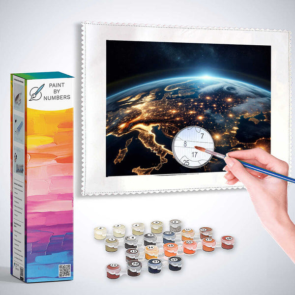 "Paint by Numbers kit Enlightened Earth showing a hand painting illuminated Earth amidst deep blue space with paint pots and packaging"