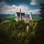 Neuschwanstein Castle surrounded by lush greenery under a partly cloudy sky