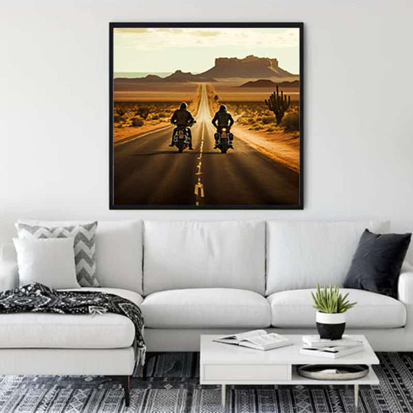 Wall art of two bikers riding on a desert road, displayed above a modern white sofa in a stylish living room.