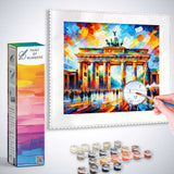 Paint by Numbers kit featuring a colorful, abstract depiction of the Brandenburg Gate with a hand painting by numbers and paint pots.