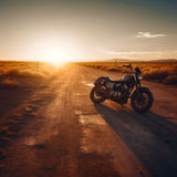 Motorcycle parked on a dirt road at sunset, surrounded by desert landscape and golden light.