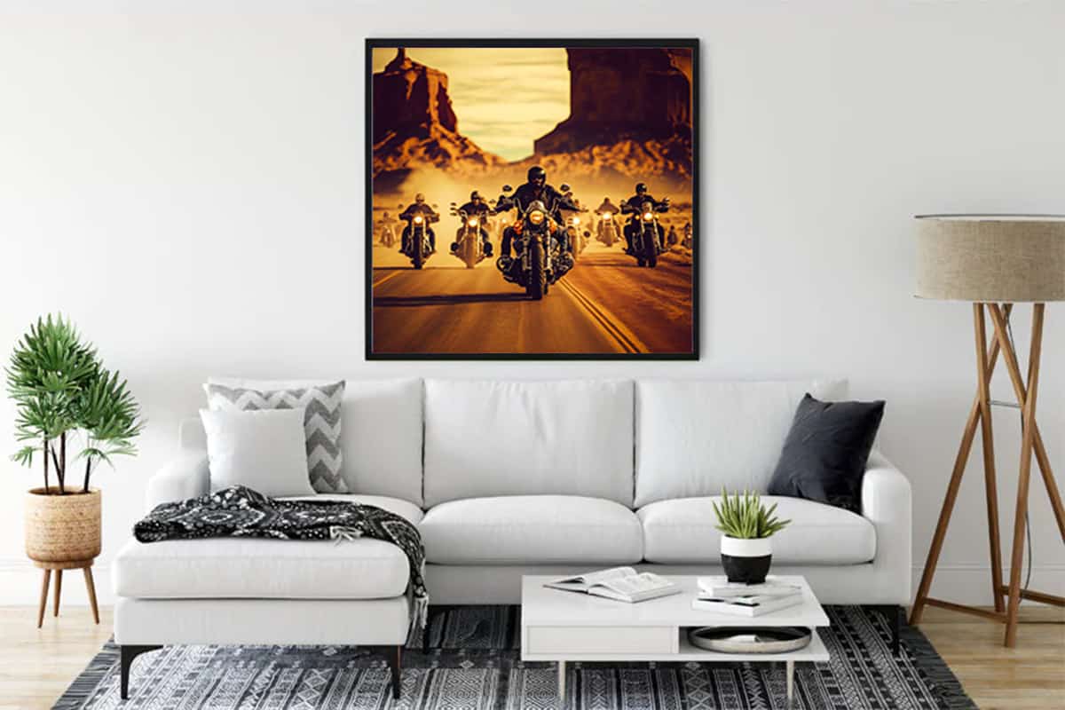 Modern living room with a stylish sofa, wall art of bikers on a desert road, indoor plant, and contemporary decor elements.