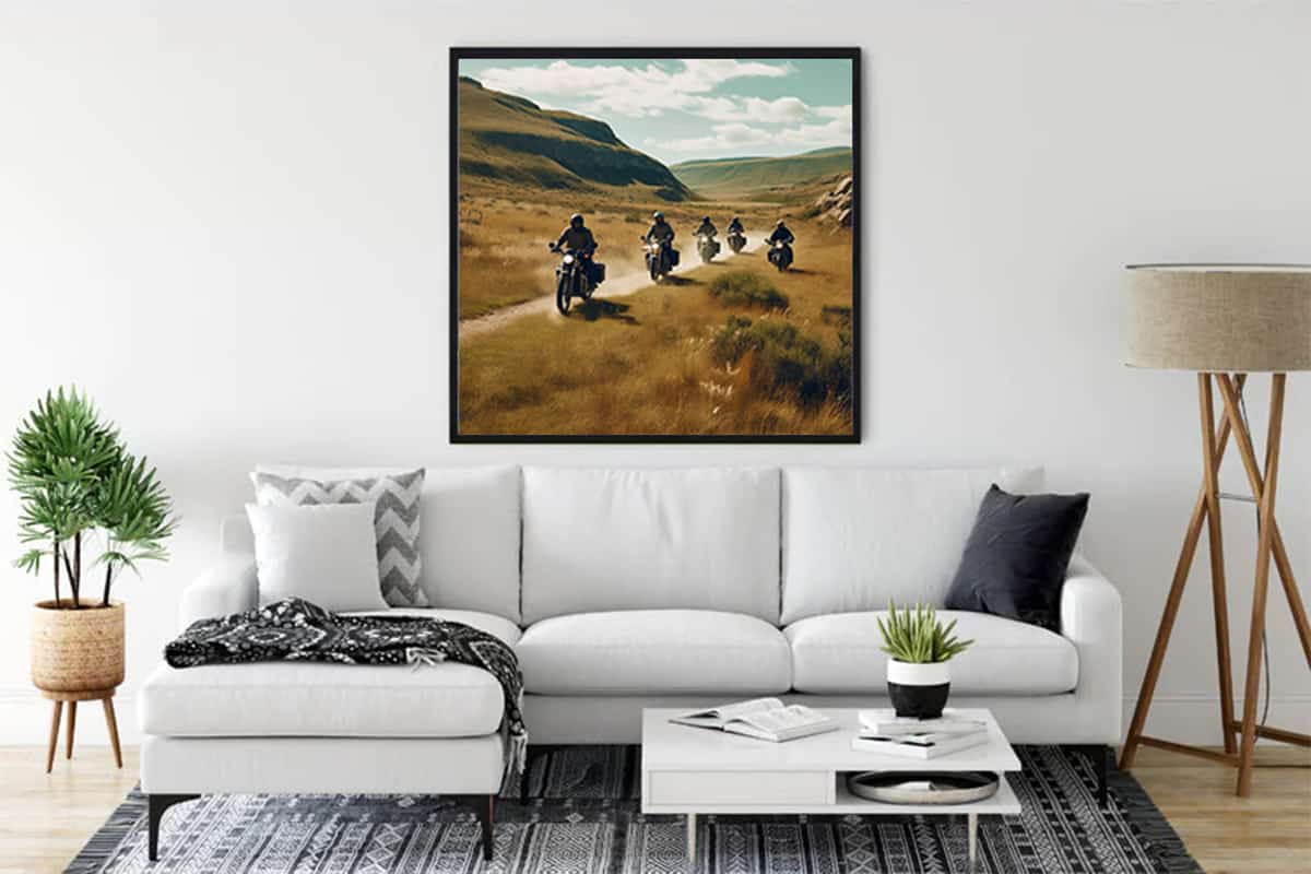 Diamond painting "Freedom on two wheels" displayed in a modern living room above a white couch, showcasing a scenic motorcycle design.