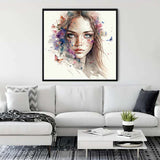 Diamond painting of an elegant woman's face hanging on a wall above a modern white couch in a stylish living room.