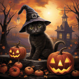 Adorable black kitten wearing a witch hat surrounded by pumpkins and Halloween decorations with a haunted house and autumn background