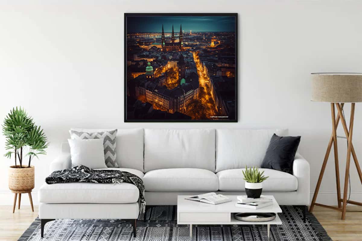 Diamond painting of Hamburg by night hung above a white sofa in a modern living room with sleek decor.
