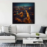 Diamond painting of Hamburg by night hung above a white sofa in a modern living room with sleek decor.