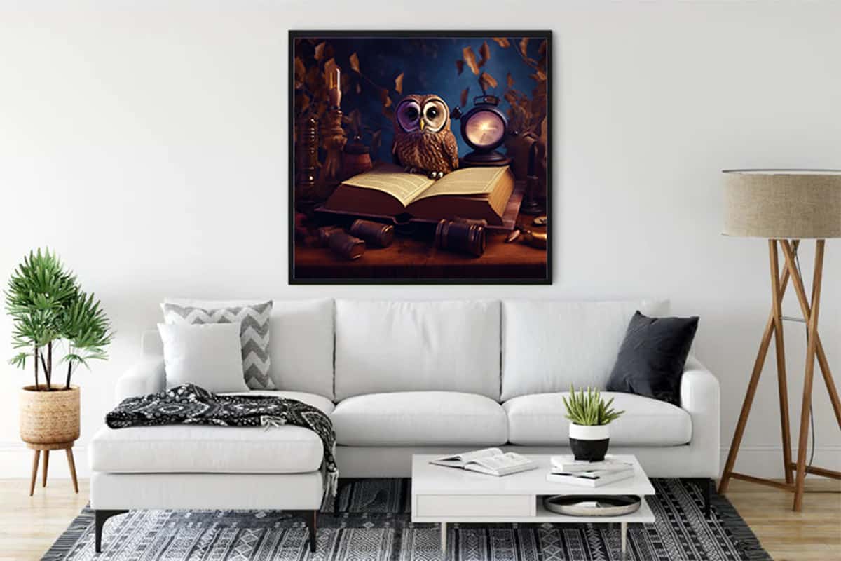 Diamond painting of an owl with book and clock hanging above a white sofa in a stylish living room.