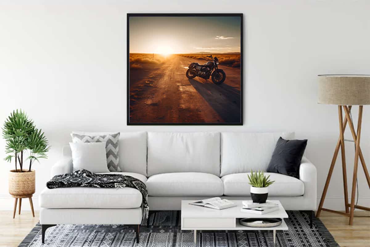 Motorcycle diamond painting on a racetrack hanging above a sofa in a modern living room.