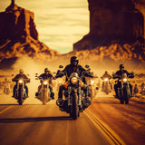 Group of motorcyclists riding through desert landscape at sunset.